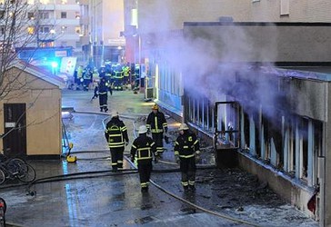 Tymi nga pjesa e brendshme një xhamie të shkatërruar, ndërsa zjarrfikësit po kryejnë detyrën e tyre, pas sulmit në xhami. (AFP)