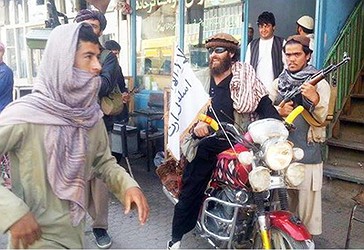 Një luftëtar taleban ulur në motorin e tij të stolisur me një flamur të talebanëve në një rrugë në Kunduz, Afganistan.