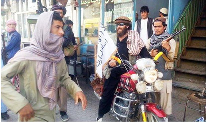 Një luftëtar taleban ulur në motorin e tij të stolisur me një flamur të talebanëve në një rrugë në Kunduz, Afganistan.