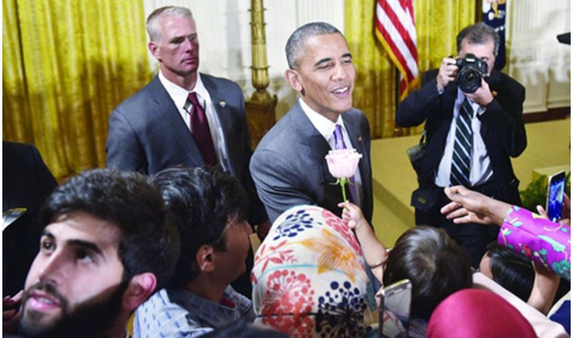 Kryetari amerikan Barack Obama merr një trëndafil  gjatë një pritje të muslimanëve  në Shtëpinë e Bardhë
