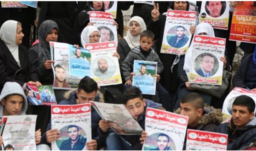 Protestuesit mbajnë postera gjatë një demonstrate, kërkojnë lirimin e palestinezëve të cilët organizojnë një grevë urie në burgjet izraelite, përballë ndërtesës së Kryqit të Kuq Ndërkombëtar në Ramallah, në Bregun Perëndimor, më 28 shkurt, 2017.